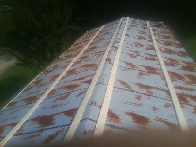 Rusted metal roof panels with new wood purlins before replacement — Storm Damage Roof Repair in Brandt by Roofing Brothers