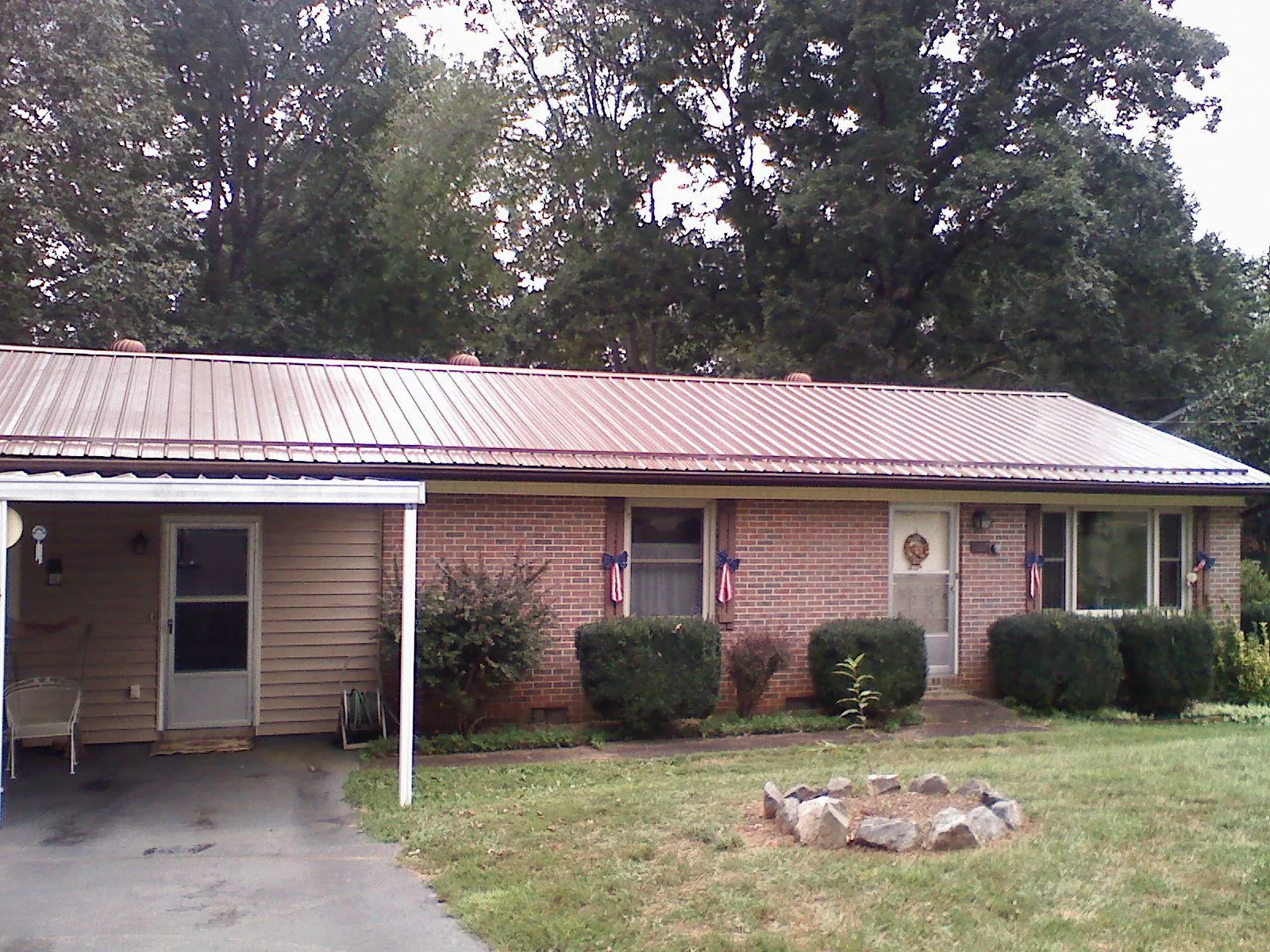 Bronze metal roof and carport on a brick ranch home — Roof Repair work by our crew in Brandt